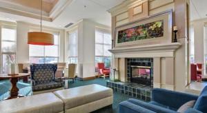 a living room with a couch and a fireplace at Hilton Garden Inn Appleton/Kimberly in Kimberly