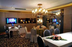 a dining room with tables and chairs and a chandelier at Xian Grand Noble Hotel in Xi'an