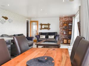 een woonkamer met een houten tafel en stoelen bij Oceans Away - Uk48571 in Woolacombe