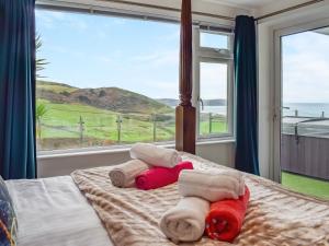 een slaapkamer met een bed met handdoeken en een groot raam bij Oceans Away - Uk48571 in Woolacombe +10 foto's
