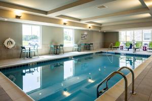 una piscina con sedie e tavoli in una camera d'albergo di Home2 Suites By Hilton Kalamazoo Southeast a Kalamazoo