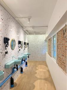 a bathroom with four sinks and a brick wall at Easy Monday Capsule Hotel Bangkok in Bangkok