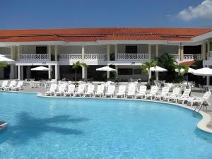 Celuisma Playa Dorada All Inclusive في Cantabria: مسبح مع كراسي ومظلات في الفندق