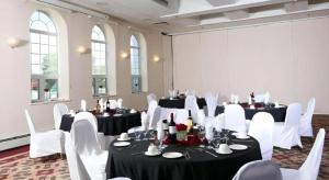 a room with white tables and white chairs and tablesearcher at Coast High Country Inn in Whitehorse