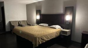 Una cama o camas en una habitación de Scottish Inns Augusta