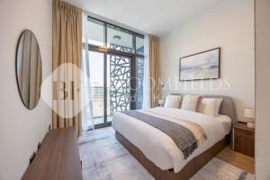 a bedroom with a bed and a large window at Bloomfields Executive 2BR Apt The Gate Masdar in Abu Dhabi
