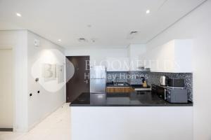 a kitchen with white walls and a counter top at Bloomfields Executive 2BR Apt The Gate Masdar in Abu Dhabi +15 photos