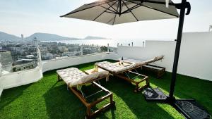a balcony with a table and chairs and an umbrella at Mali Villa 57 in Patong Beach