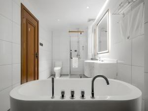 a white bathroom with a sink and a toilet at GME Taizhou Jingjiang City Bus Station Hotel in Jingjiang +131 photos