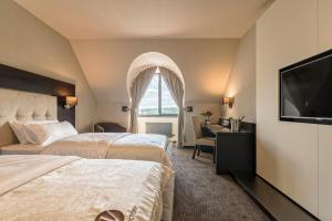 een hotelkamer met 2 bedden en een flatscreen-tv bij Hotel Victory in Brno