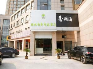 a building with cars parked in front of it at GreenTree Inn Nanjing Baijiahu in Jiangning