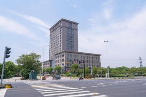 GreenTree Inn Wuxi Quanshan Center في ووشي: مبنى طويل في وسط شارع
