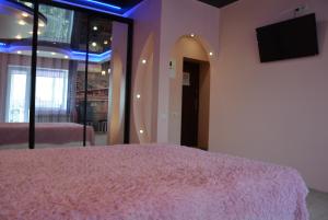 a bedroom with a bed with a pink blanket at 24home in Dnipro