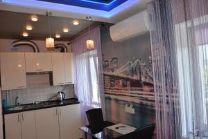 a kitchen with white cabinets and a table and a window at 24home in Dnipro