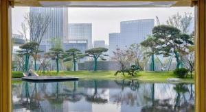 una ventana con un barco en el agua en una ciudad en Twinkle hotel Hangzhou, en Hangzhou