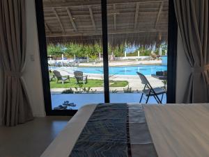 a bedroom with a bed and a view of a pool at Banana Beach Club in Moalboal
