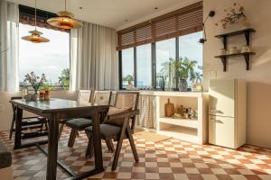 a kitchen with a table and chairs and a refrigerator at Than Coffee & Homestay in Hai Phong