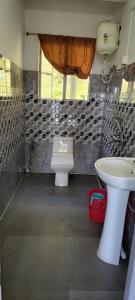 a bathroom with a toilet and a sink at Queen's Nest Homestay in Takdāh