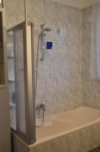 a bath tub with a shower in a bathroom at Ferienwohnung Familie Stuhr in Staatz