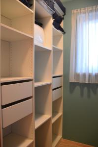 a walk in closet with white shelves and a window at Ferienwohnung Familie Stuhr in Staatz