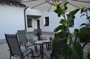 un patio con mesa, sillas y sombrilla en Ferienwohnung Familie Stuhr, en Staatz