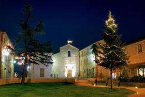 a christmas tree in front of a church at night at Bed and Breakfast San Firmano in Montelupone