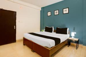 Collection O KIIT Square Bhubaneswar Formerly Nilay Classic في Bārang: غرفة نوم بسرير كبير وجدار أزرق