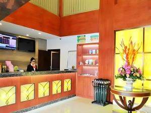 GreenTree Inn Qingdao Licang Shuyan Road Daweng Square Express Hotel في Laoshan: امرأة تقف في كونتر مطعم