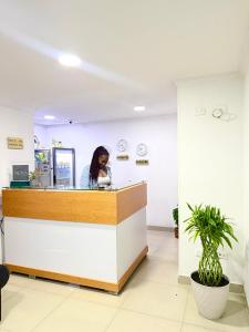 a woman sitting at a counter in an office at Hotel MOVA in Medellín
