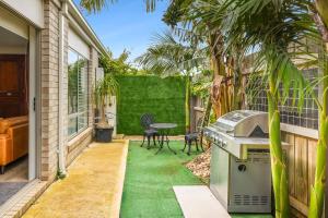 een achtertuin met groen gras en een grill bij Palms by the sea in Saint Leonards