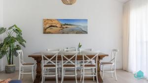 een eetkamer met een tafel en stoelen bij Oceanview Beach House in Caves Beach