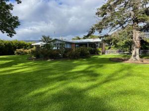 a house with a large yard with green grass at wyeangta - Woodbridge Waterfront Retreat in Woodbridge