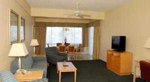 a living room with a couch and a tv at Chart House Suites and Marina in Clearwater Beach