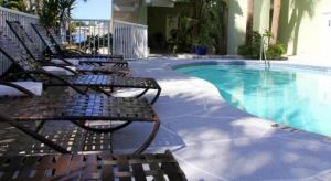 a group of chairs sitting next to a swimming pool at Chart House Suites and Marina in Clearwater Beach +33 photos