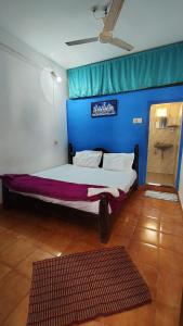 Laxmi في أرامبول: غرفة نوم بسرير كبير وجدار أزرق