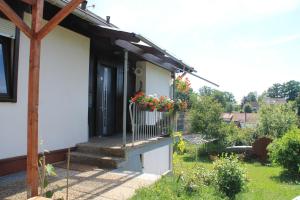 ein Haus mit einer Veranda mit Blumen darauf in der Unterkunft Apartment Bergblick Bischberg bei Bamberg in Bischberg