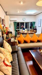 a living room with a brown couch with orange pillows at Grace House Hill Paradise Atami in Atami