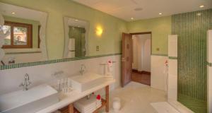 um banheiro com duas pias e um chuveiro em Almanara Luxury Boutique Hotel and Villas em Praia de Diani mais 16 fotografias