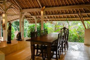 a dining room with a wooden table and chairs at Nomadic Resort Bali in Canggu