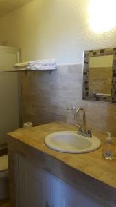 een badkamerbar met een wastafel en een spiegel bij Casa Pok Tapok in Cancun