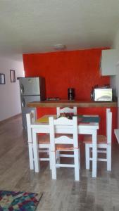 cocina con mesa, 2 sillas y barra en Casa Pok Tapok, en Cancún