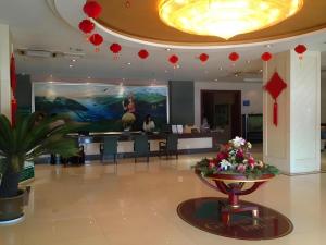 a lobby with a table with flowers in the middle at GreenTree Inn Xuzhou South Minzhu Road in Xuzhou