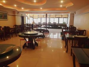 a restaurant with tables and chairs in a room at GreenTree Inn Xuzhou South Minzhu Road in Xuzhou