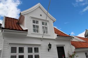 a white house with a red roof at Skuteviken Apartments Anno 1790 in Bergen