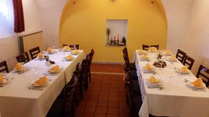a row of tables in a restaurant with white table cloths at Gostilna Stara Pošta in Podkraj