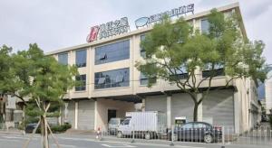 Jinjiang Inn Taizhou Huangyan Jiufeng Park في Daidong: مبنى كبير مع سيارات متوقفة أمامه