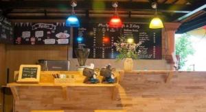 a counter in a restaurant with a menu on the wall at Phumorkdao Resort in Pong Yaeng