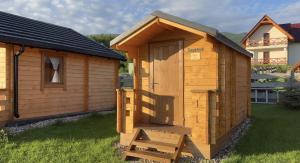 a wooden out house with a ladder in a yard at Osada w Karkonoszach in Kowary +1 photo