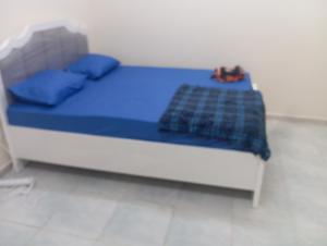 a small bed with blue sheets and blue pillows at Cozy room in Sharjah