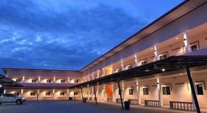 a large building with a car parked in a parking lot at The Phant Hotel in Ban Salak Dai